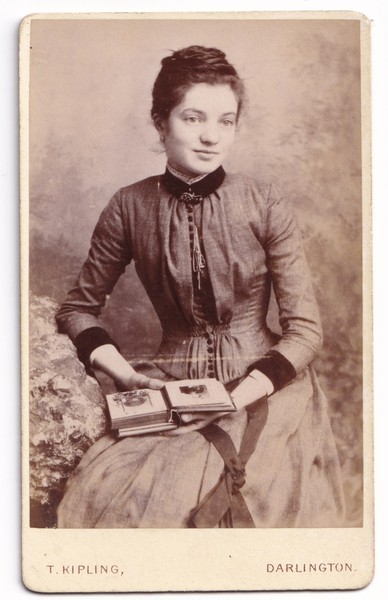 CDV: CDV: Portrait of a Young Woman Holding Photograph Album. T. Kipling, Darlington.: catalogue image 1