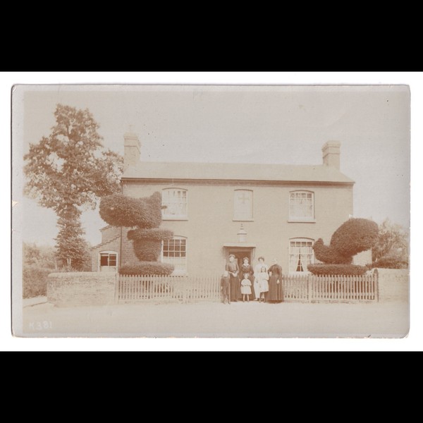 Postcard: Postcard Unidentified House, Family. Distinctive Topiary Bushes, Cross in Window: catalogue image 1